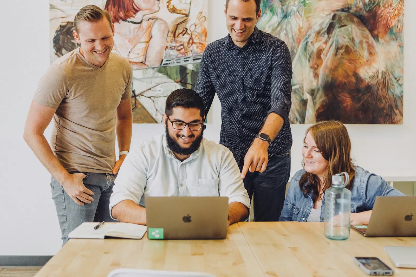 Equipe reunida em torno de um notebook